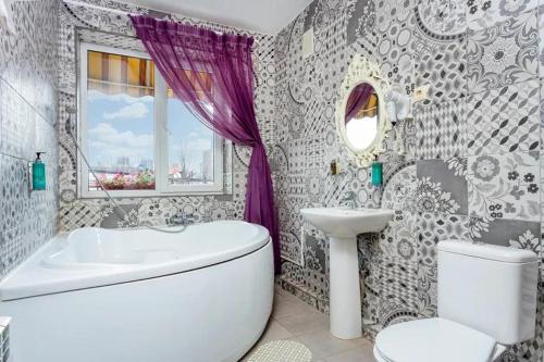 a bathroom with a toilet and a sink and a tub at Marton Boutique and Spa Krasnodar in Krasnodar