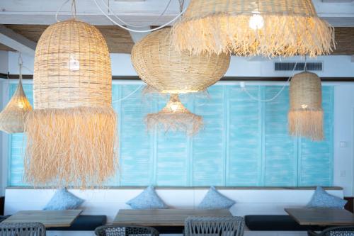 a restaurant with two chandeliers and a table with chairs at Beachhouse Isleten in Bauen