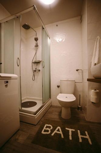a bathroom with a shower and a white toilet at Apartman Gold in Slavonski Brod