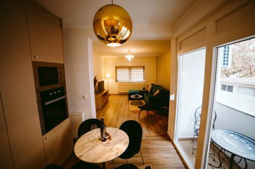 Habitación con mesa, sillas y sala de estar. en Apartman Gold en Slavonski Brod