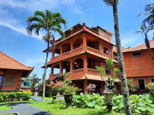 a building with palm trees in front of it at Gayatri in Ubud
