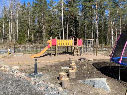 a playground with a slide in a park at Tiny house in the middle of nature in Åkersberga
