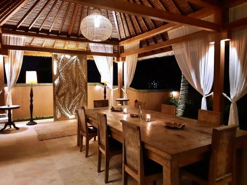 a dining room with a wooden table and chairs at Gayatri in Ubud