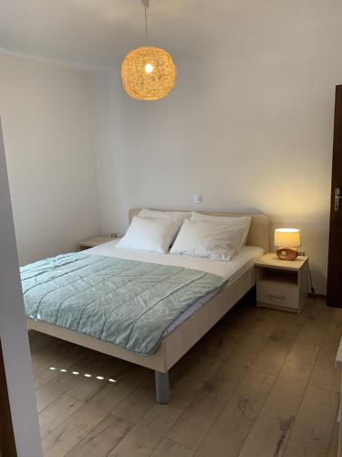 a bedroom with a bed and a light fixture at Apartments Epidaurus in Cavtat