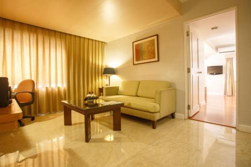 a living room with a couch and a table at The Linden Suites in Manila