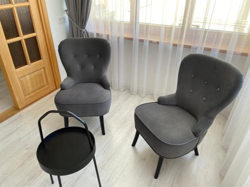 two chairs and a stool in a room at Astos Vila in Palanga