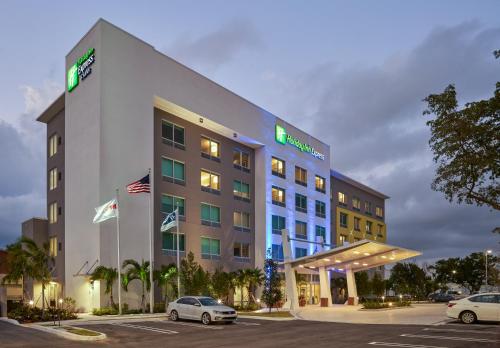 a hotel with cars parked in a parking lot at Holiday Inn Express Doral Miami by IHG in Doral