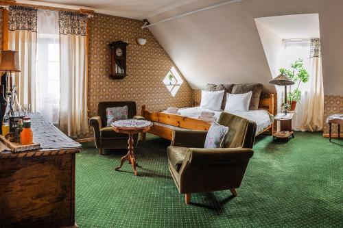 a bedroom with a bed and chairs and a table at Pakruojis Manor Hotel Miller's house in Pakruojis