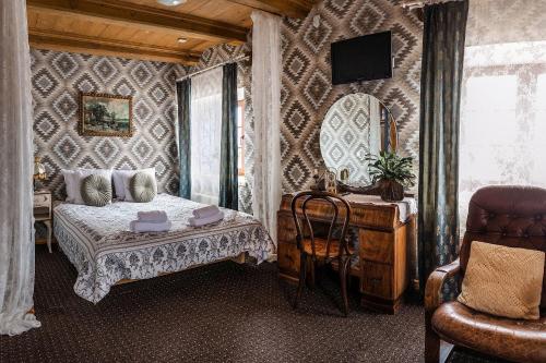 a bedroom with a bed and a desk and a mirror at Pakruojis Manor Hotel Miller's house in Pakruojis