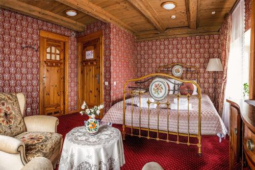 a bedroom with a bed and a table and a chair at Pakruojis Manor Hotel Miller's house in Pakruojis