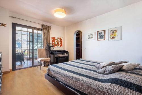 a bedroom with a bed and a desk and a window at Casa Tatiana in Acantilado de los Gigantes