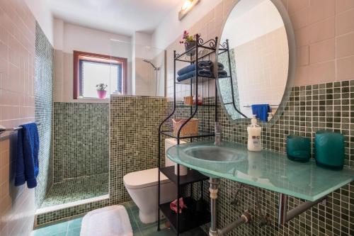 a bathroom with a sink and a mirror and a toilet at Casa Tatiana in Acantilado de los Gigantes
