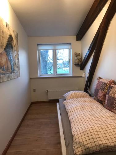 a bedroom with two beds and a window at Askegaarden Apartments in Sandved