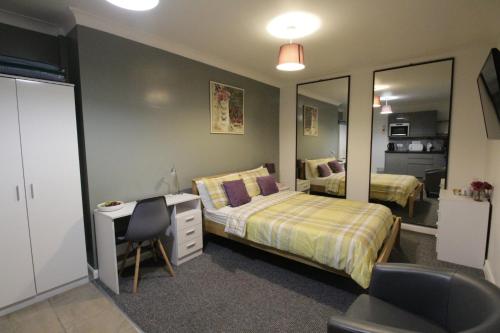 a bedroom with a bed and a desk and a mirror at Tennyson in Lincoln