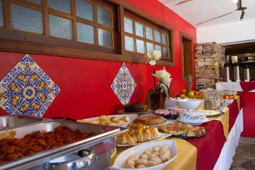 Un buffet con muchos tipos diferentes de comida en una mesa. en Hotel Pousada Arcádia Mineira, en Ouro Preto