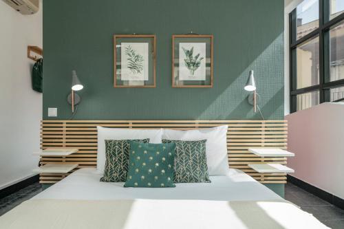 豐沙爾的住宿－Pelourinho Apartments by An Island Apart，一间卧室配有一张带两盏灯和两个枕头的床。