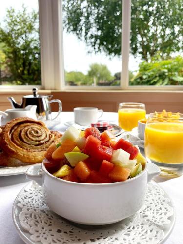 a bowl of fruit on a table with a plate of food at Abbey Court in Nenagh