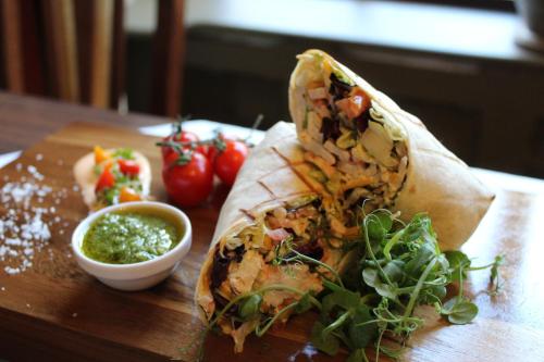 a burrito on a cutting board with a bowl of sauce at Abbey Court in Nenagh
