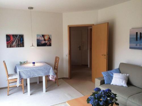 uma sala de estar com uma mesa e um sofá em Appartement-Konsulweg-KON-375 em Scharbeutz