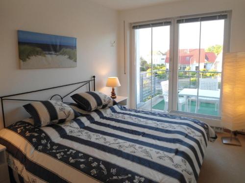 a bedroom with a bed with a view of a balcony at Appartement-Konsulweg-KON-375 in Scharbeutz