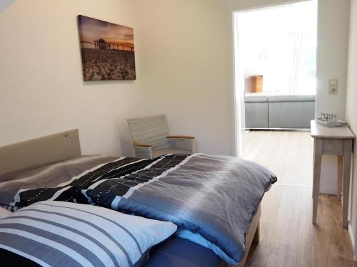 ein Schlafzimmer mit einem Bett und einem Stuhl in einem Zimmer in der Unterkunft Appartement Silbermöve AMH/002 in Scharbeutz