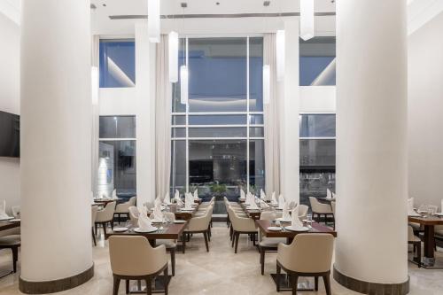 فندق قمر جدة في جدة: مطعم فيه اعمدة بيضاء وطاولات وكراسي