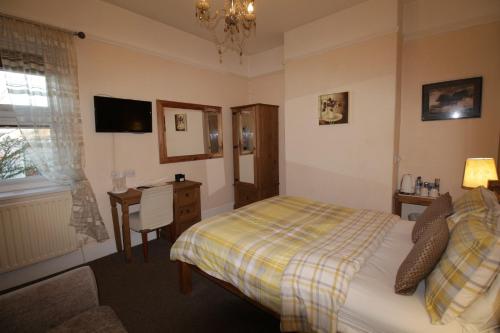 a bedroom with a bed and a table and a desk at Tennyson in Lincoln