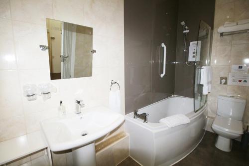 a bathroom with a sink and a tub and a toilet at Tennyson in Lincoln