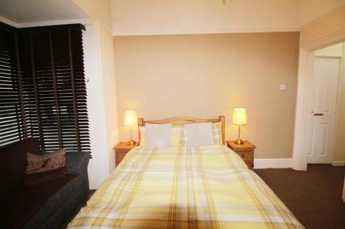 a bedroom with a bed with a plaid blanket at Tennyson in Lincoln