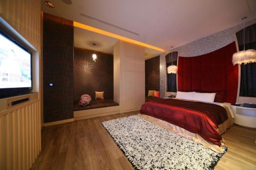 a bedroom with a bed and a flat screen tv at Hua Mu Lan Hotel in Shalu