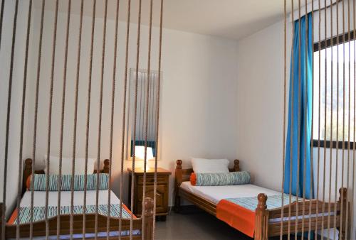 a bedroom with two beds with blue curtains at Yeshill Apart & Studio in Budva
