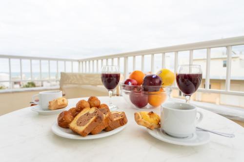 - une table avec deux verres de vin et une assiette de nourriture dans l'établissement Ibiscos Garden Hotel, à Réthymnon