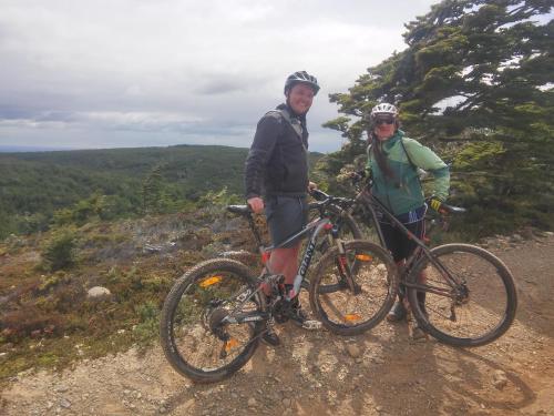 duas pessoas em pé em uma colina com suas bicicletas em Casa Bike em Punta Arenas