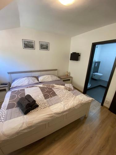 a large bed in a bedroom with a mirror at Penzion U Adama in Karlštejn
