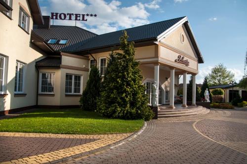 a hotel with a christmas tree in front of it at Dworek Jolanta in Biała Podlaska