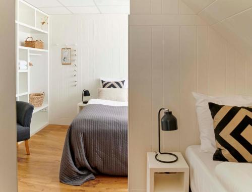 a small bedroom with a bed and a chair at Hotel Zonne in Noordwijk aan Zee