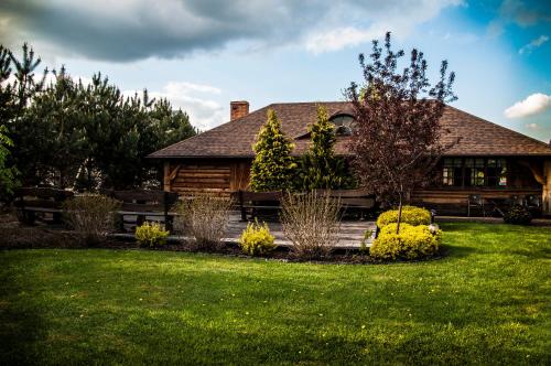 a log cabin with a yard in front of a house at Dworek Jolanta in Biała Podlaska