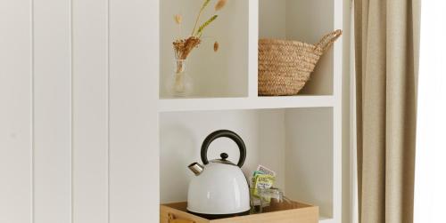 a tea kettle sitting on a shelf in a bathroom at Hotel Zonne in Noordwijk aan Zee