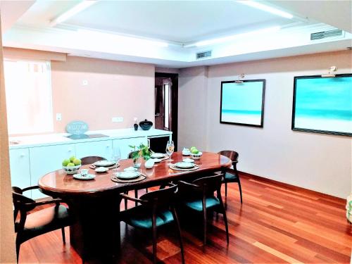 - une salle à manger avec une table et des chaises en bois dans l'établissement LARGE Apartment with large and sunny Terrace - Garden & Outdoor Gym , ALICANTE CENTER, à Alicante