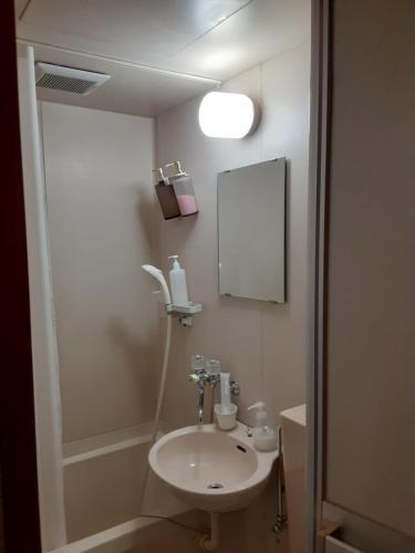 ein Bad mit einem Waschbecken und einem Spiegel in der Unterkunft OHTO Ryokan in Kyoto