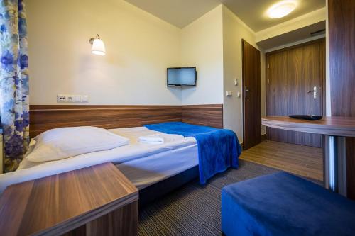 a hotel room with a bed and a tv at Leśne Patio in Katowice