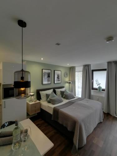 a bedroom with a large bed and a table at RhePi-Apartment in Essen