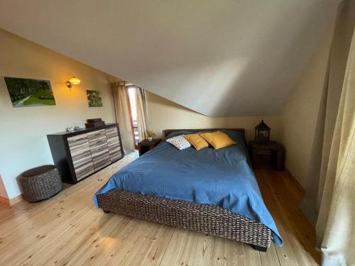 Schlafzimmer mit einem Bett mit blauer Decke in der Unterkunft Sunset Beach House in Tūja
