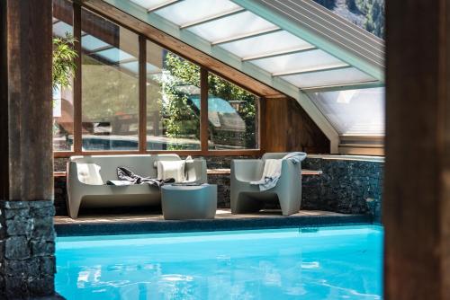 - une piscine avec une rangée de chaises à côté de la piscine dans l'établissement Club Alpina - Champagny-en-Vanoise, à Champagny-en-Vanoise