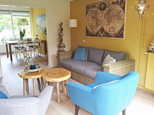 een woonkamer met een bank, stoelen en een tafel bij Vakantiehuis Boulevard in Vlissingen
