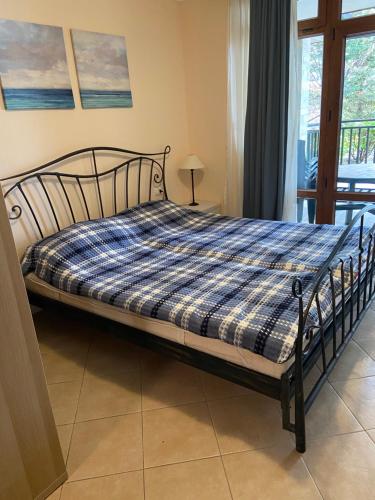 a bed in a bedroom with a blue plaid blanket at Tiny Bijou Sea View studio - Santa Marina - Sozopol in Sozopol