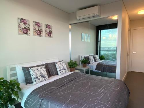 a bedroom with a large bed and a large mirror at Park-City view in Sydney Olympic Park in Sydney