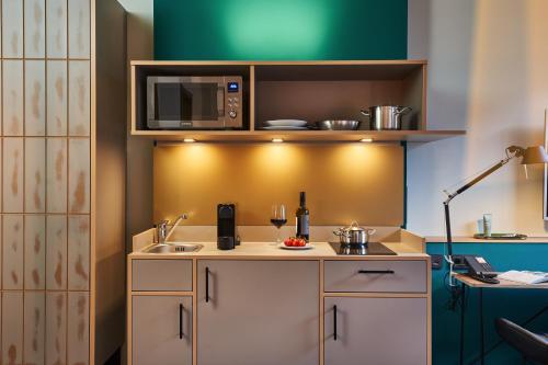 eine Küche mit einer Spüle und einer Mikrowelle in der Unterkunft hood house in Hamburg