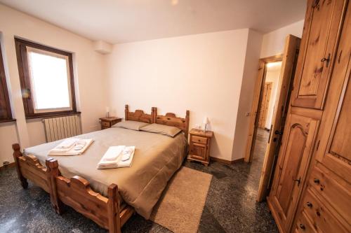 a bedroom with a bed with two towels on it at Appartamenti Pirovano Valdidentro in Isolaccia