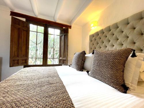 a bedroom with a large bed with a large headboard at Hotel Casa Terra in Villa de Leyva